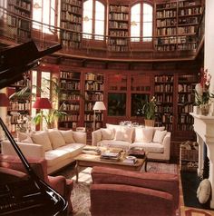 a living room filled with lots of furniture and bookshelves next to a piano