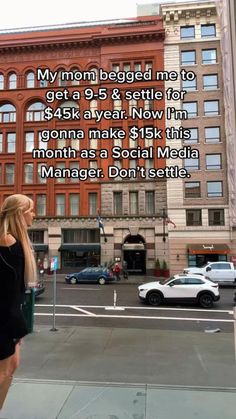 a woman is standing on the sidewalk in front of a building with an ad for social media manager don't set