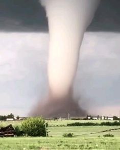 a large tornado is in the sky over a field
