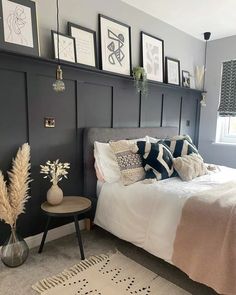 a bedroom with gray walls and pictures on the wall