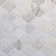 a white marble mosaic tile with blue lines and wavy shapes on the bottom half of it