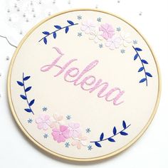 a embroidery kit with the word hello written in pink, blue and white flowers on it