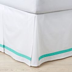 a bed with a white and green bedskirt