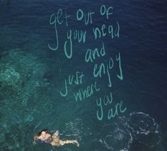 a woman swimming in the ocean with words written on her wall above her head and below her body