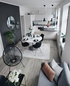 living room designs layout with grey walls and white carpeted flooring, round dining table surrounded by black chairs