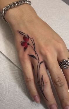 a woman's hand with a flower tattoo on it
