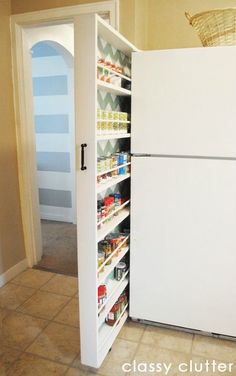 a white refrigerator freezer sitting inside of a kitchen next to a pantry filled with food