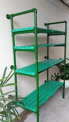 a green metal shelf next to a potted plant