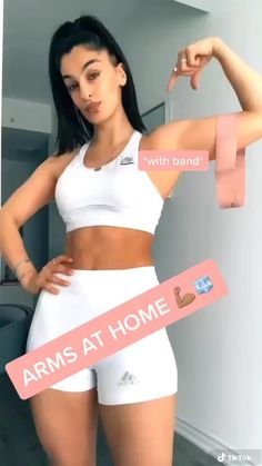 a woman in white shorts and bra top with arms at home tape around her waist