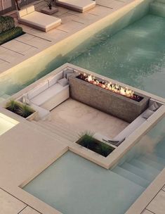 an outdoor fire pit in the middle of a swimming pool