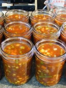 many jars filled with soup sitting on top of a counter next to a stovetop
