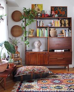 a living room filled with lots of furniture and plants on top of it's shelves