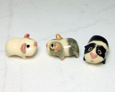 three small figurines of mice on a white surface