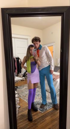 a man and woman taking a selfie in front of a mirror with clothes on