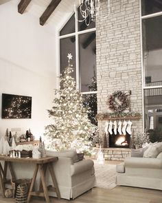 a living room filled with furniture and a christmas tree in front of a fire place