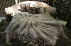 a bed covered in animal print pillows and blankets
