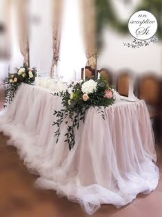 a table with flowers and candles on it in the middle of a room that is decorated for a wedding