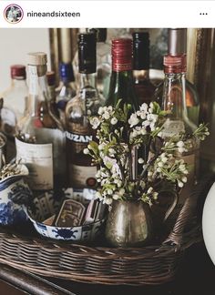 a wicker basket filled with liquor bottles and flowers