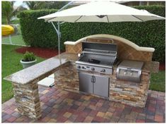 an outdoor bbq with grill and umbrella