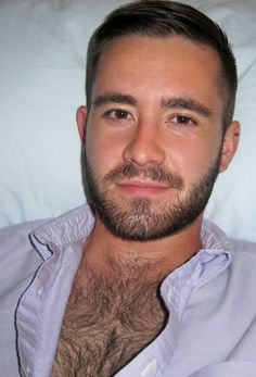 a man with a beard laying in bed