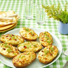a white plate topped with mini potatoes on top of a green and white checkered table cloth