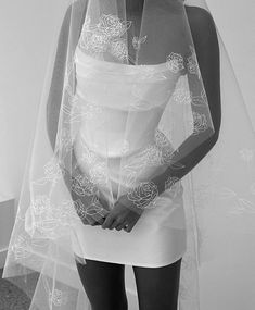 black and white photograph of a woman wearing a wedding veil with roses on the side
