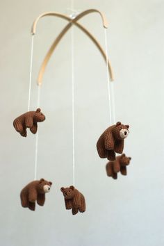 three stuffed bears hanging from a string in the shape of a bear with two cubs attached to it