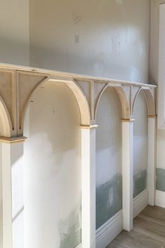 an empty room with white walls and arches