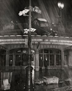 a black and white photo of a street sign in the rain