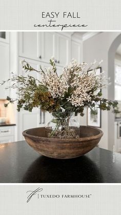 a wooden bowl filled with flowers on top of a table