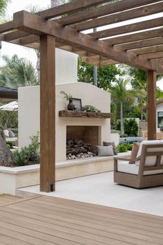 an outdoor fireplace and seating area with wood flooring