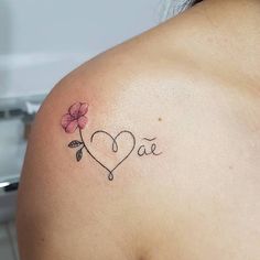 a woman with a tattoo on her shoulder has a heart and flower in the middle