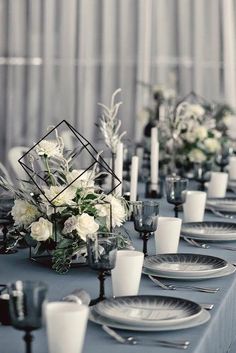 the table is set with white flowers and place settings for an instagram wedding party