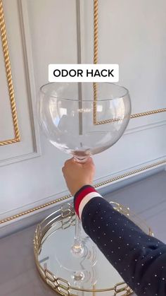 a person holding up a wine glass with the word odd hack on it in front of them