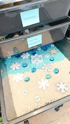 a display case with snowflakes and ice cubes on the bottom, surrounded by other items