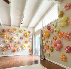 a room filled with lots of balloons on the wall next to a wooden floor and ceiling