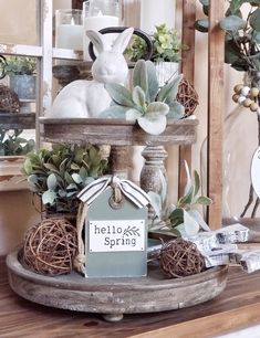 a wooden shelf topped with plants and a bunny figurine sitting on top of it