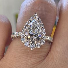 a woman's hand with a diamond ring on top of her finger and an engagement ring in the middle
