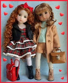 two dolls standing next to each other with hearts on the wall in the back ground