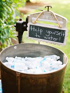 a bucket filled with water next to a sign that says help yourself to water on it