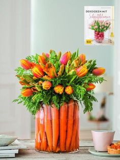 a vase filled with lots of carrots on top of a table