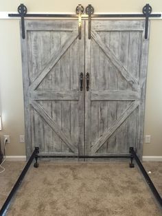 an old barn door with black hardware is shown in this bedroom setting, and it has carpeted flooring on both sides