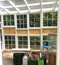 the inside of a greenhouse with lots of windows and other things on the ground in front of it