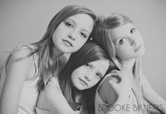 three girls are posing for the camera in black and white