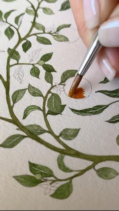 a person is drawing leaves on paper with a marker