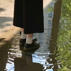 a person standing in the water with their shoes on