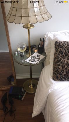 a bedroom with a lamp, phone and other items on the table next to the bed