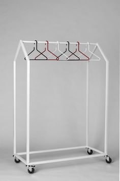 a white rack with four hangers on it