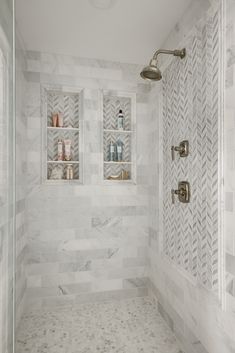a bathroom with white marble walls and flooring, including a walk - in shower