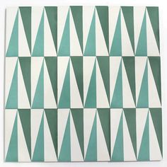 a green and white tile with triangles on it